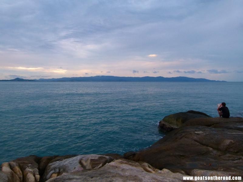 Nick reading a book on the rocks at sunset, Koh Phangan, Thailand