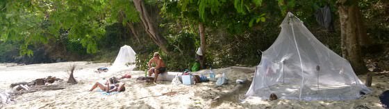 budget backpackers camping alone on an island in the philippines