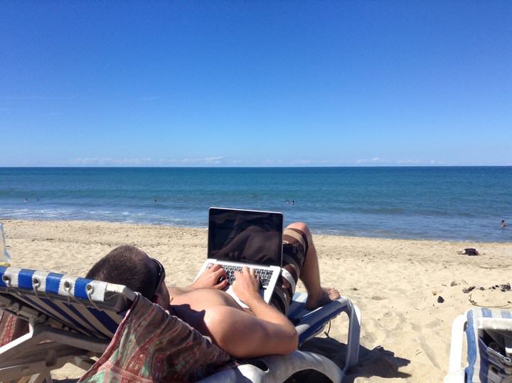101 Finest Journey Jobs To Make Cash in 2023 48 Nick working on his travel blog from the beach.