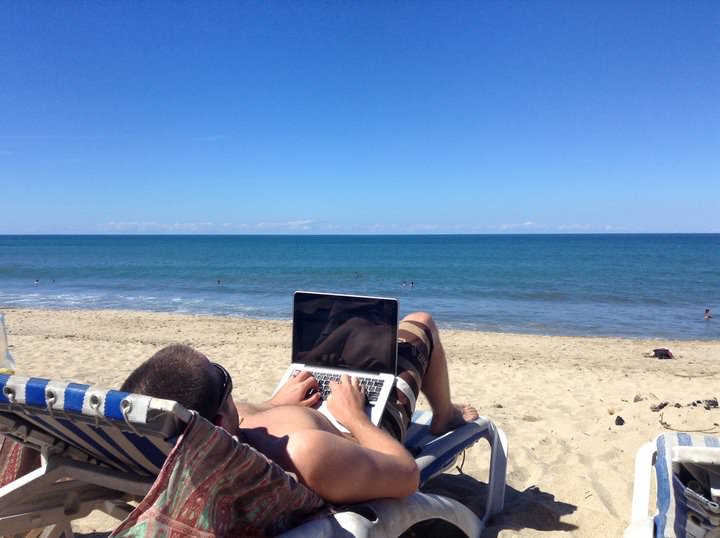 Nick working on his travel blog from the beach.