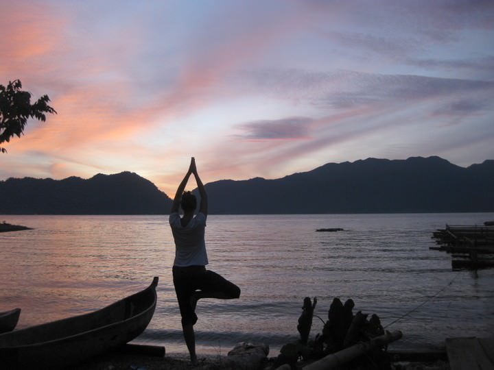 Dariece is doing yoga on the beach in Indonesia at sunset