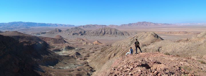 hiking high in the mountains. A photo of Nick & Dariece of Goats On The Road on top of the mountains in Tajikistan looking out at the view.