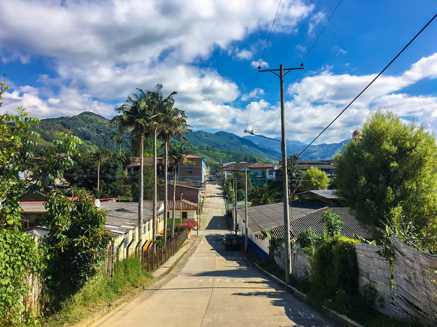 one of the main streets in the town of Salento, surrounded by mountains. This is one of the top backpacking spots in Colombia