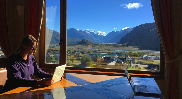 dariece working from her laptop while travelling with a view from the hotel