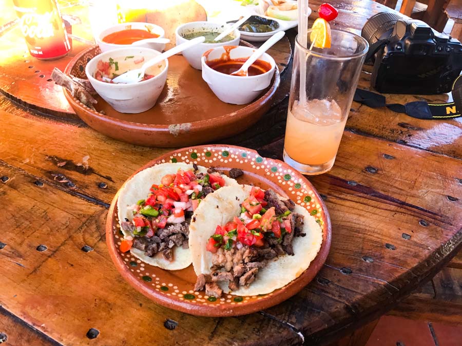 eating delicious tacos in mexico with spicy sauce