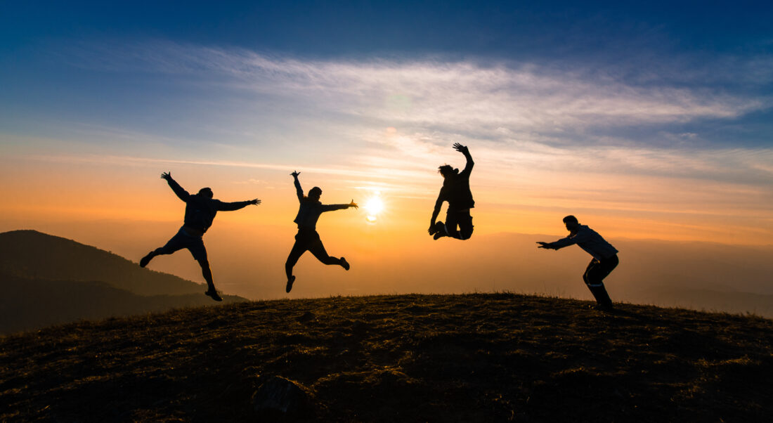 working on a new website people jumping at sunset