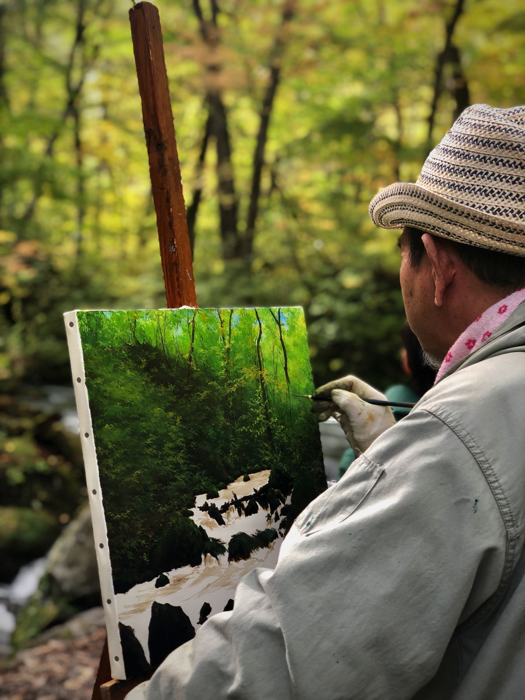 Man painting a scene in Oirase