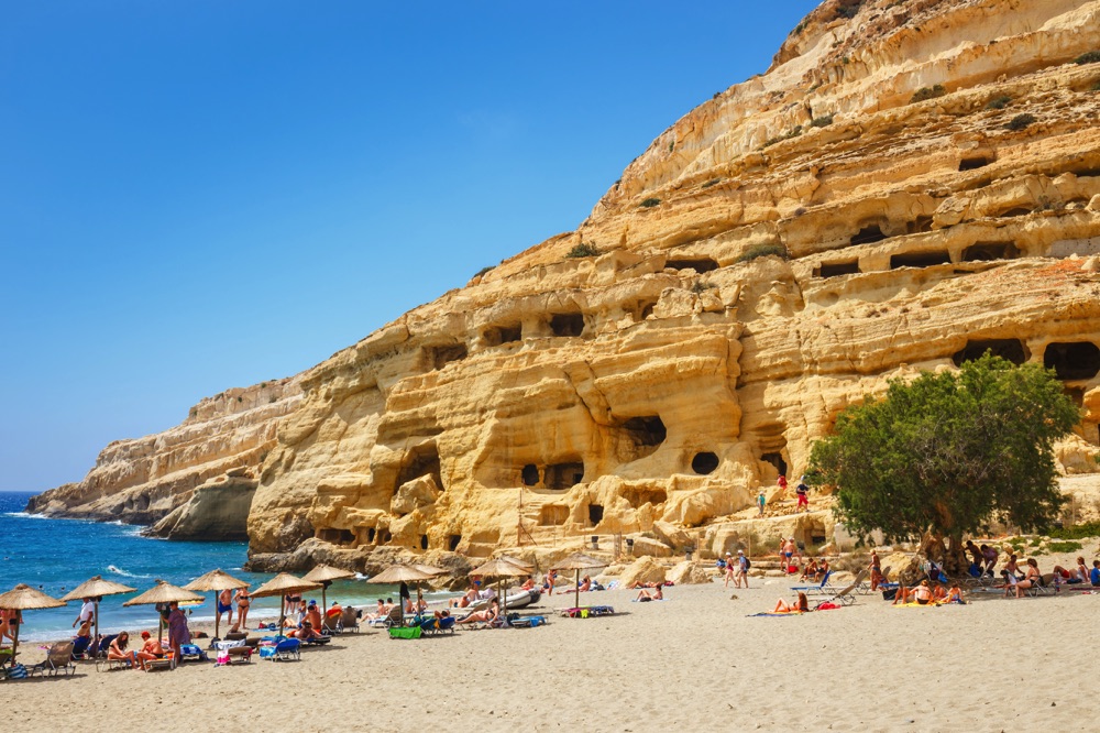 Weathered cliffs over the beach at Matala. Spending a day in the sand is one of my favorite things to do in Crete, Greece.