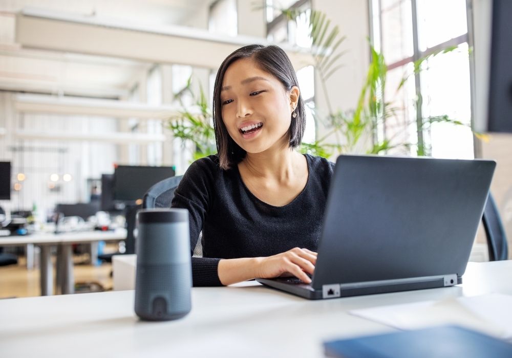 woman sitting at her desk with a laptop making money online as a virtual assistant