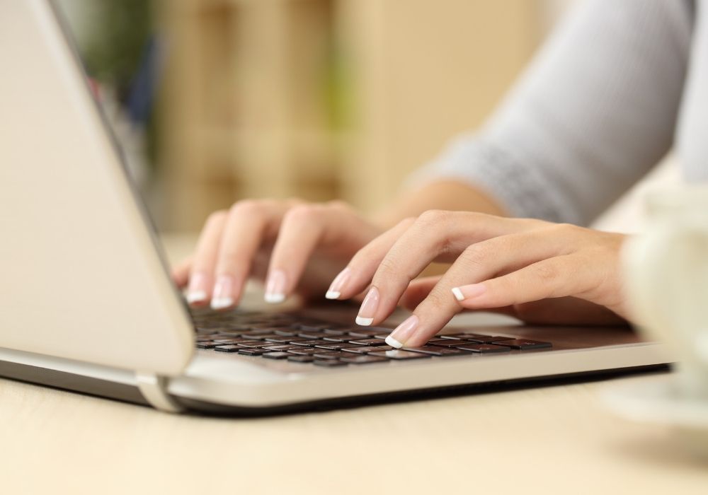 A woman typing on her computer. Closeup of the keyboard