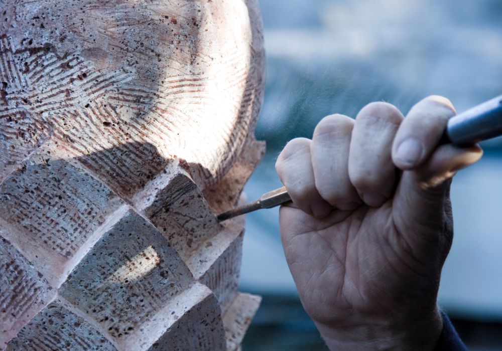 Chiseling a statue. Shopping for handicrafts is one of the best things to do in Naxos, Greece.