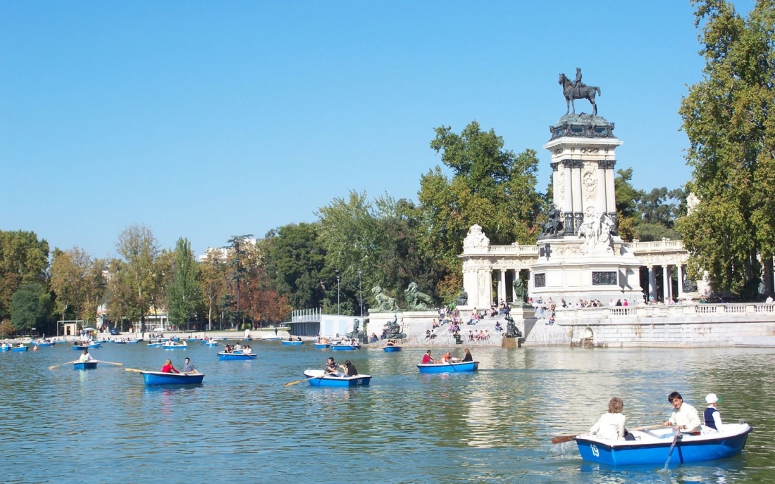 A lot of people are kayaking in the beautiful park of El Retiro in Madrid, Spain.