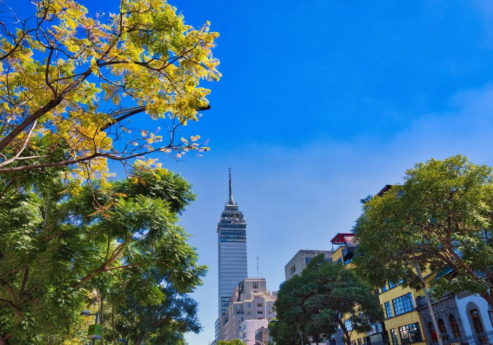 Landmark tower Torre Latinoamericana near the Alameda Central Park with some trees around the area.