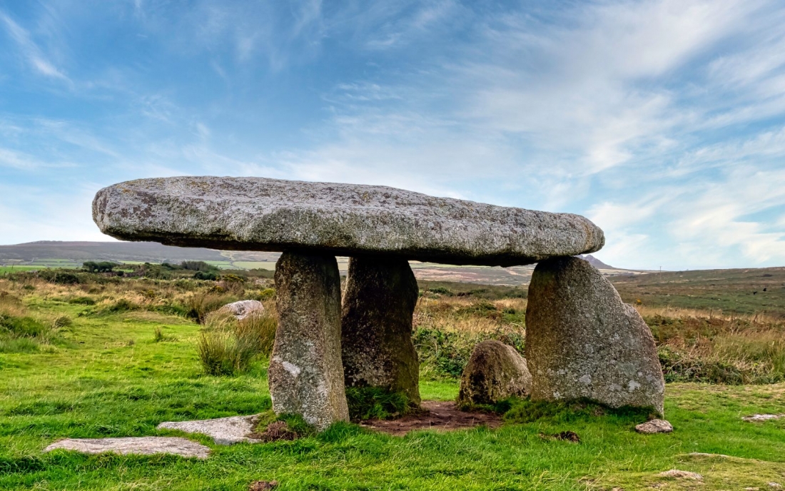 A megalithic monument or dolmen in a bright blue sky in the South-West of England.