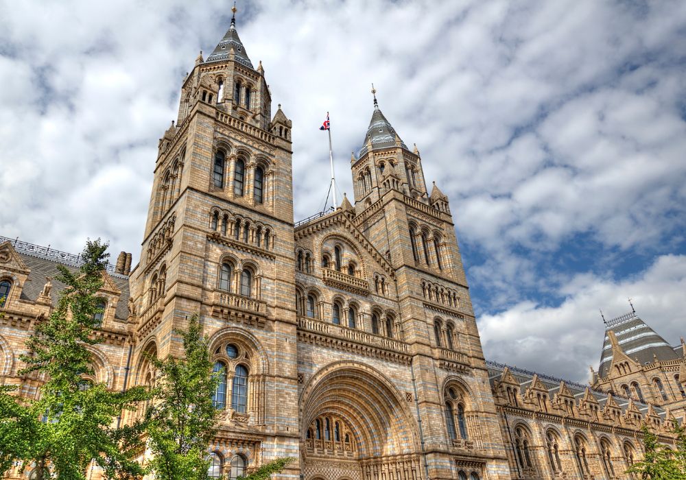 The Natural History Museum London with a cloudy skies on the background.