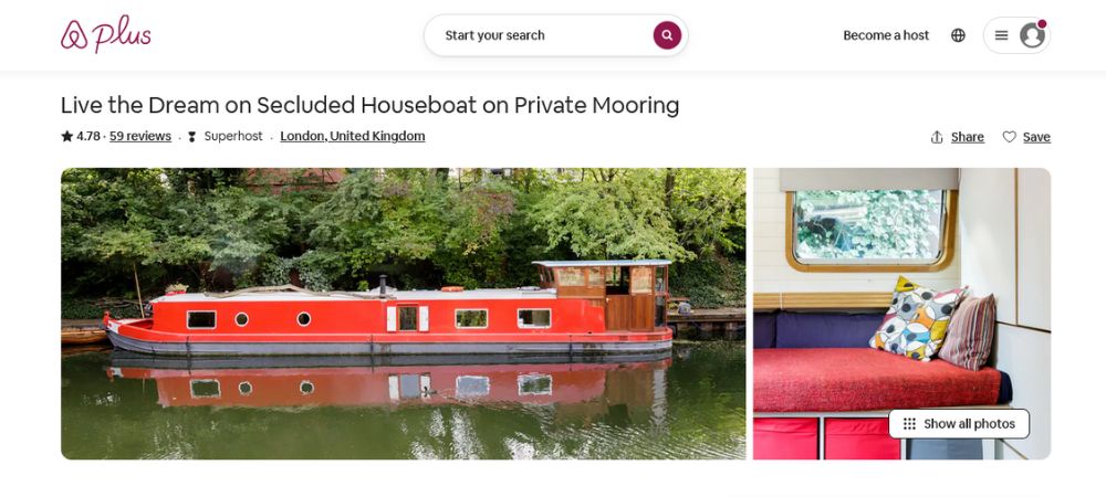 A barge in a canal is beautifully decorated with wooden fixtures, and a kitchen and dining area.