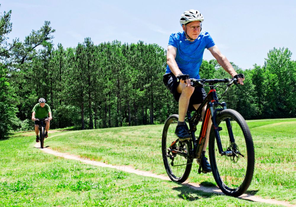 Senior men riding bikes on trail.