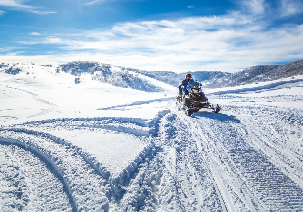 driving a snowmobile on the ice and snow in the mountains of Montana