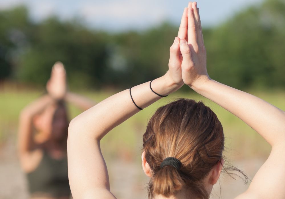 A young woman doing yoga outdoors.