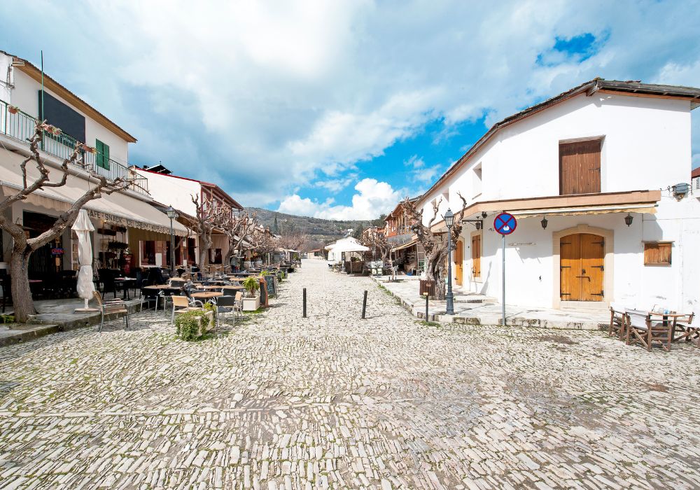 The town center of Omodos is lined with cafes, taverns, and restaurants, with cobbled pavement and rough stone walls. 