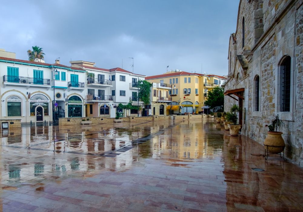 Central square of Larnaca with shops and restaurants. Reflections after the rain.