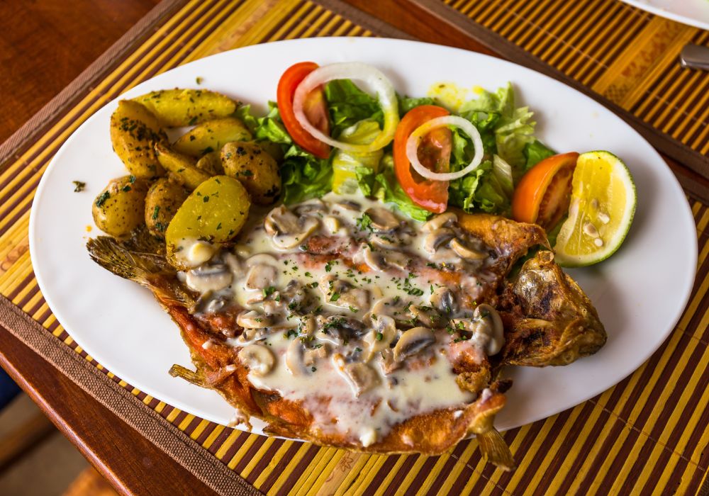 Fried trout with mushroom sauce and tomatoe salad and lettuce.