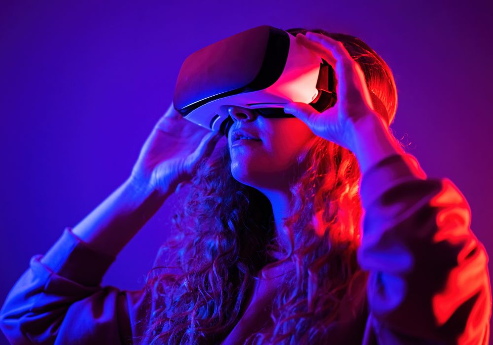 Young girl in virtual reality glasses with blue and red illumination in the room.