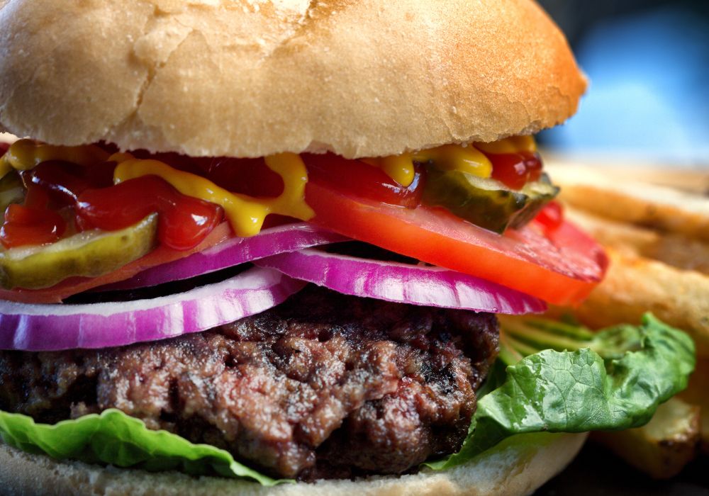 Close shot of a gourmet burger with handcut fries on the side