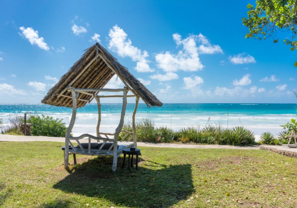 A shaded resting place with a thatched roof along Diani Beach.