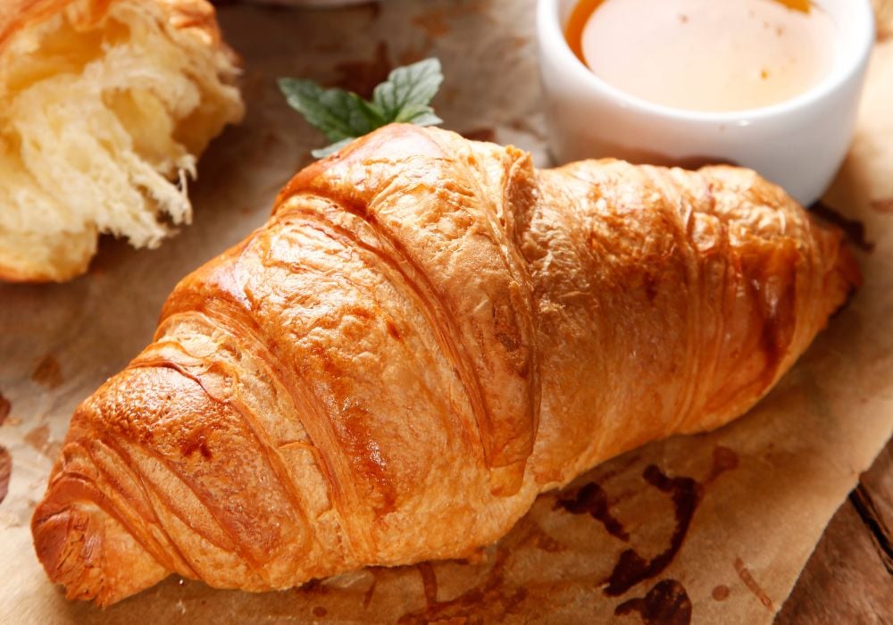 Tasty croissants with jam and honey.