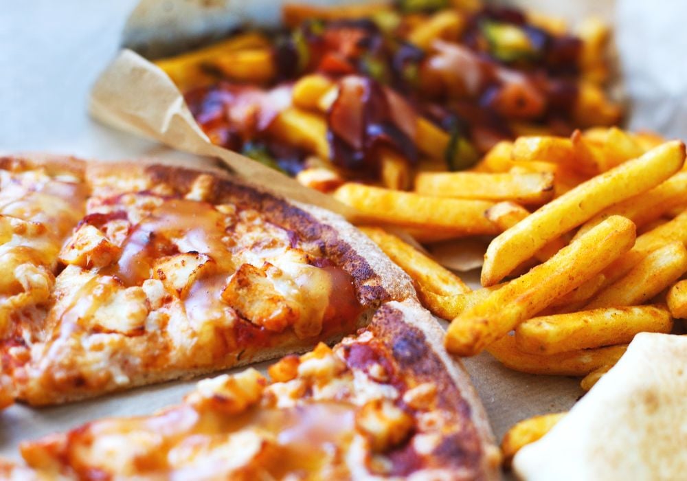 On the table is a delicious pizza and french fries.