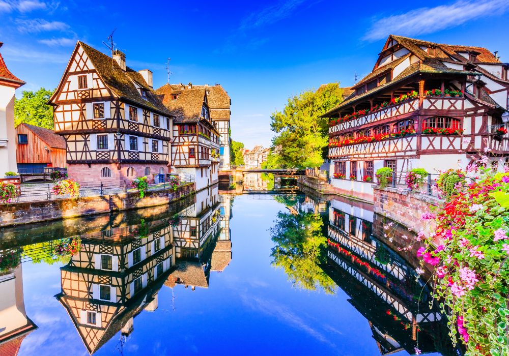 At Strasbourg in Alsace, France, you see a traditional half-timbered homes and a water canal.