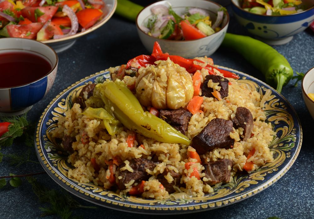 A delicious Pilaf anUzbek cuisine with a variety of vegetables on a ceramic plate.