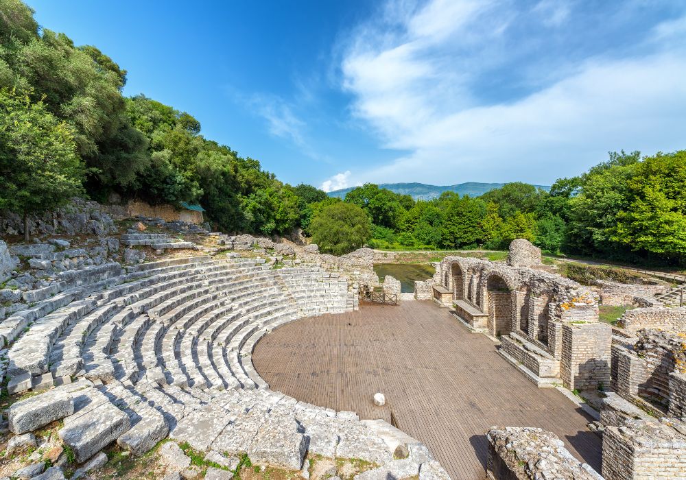 An ancient theater in Butrint, Albania, under a clear blue sky.