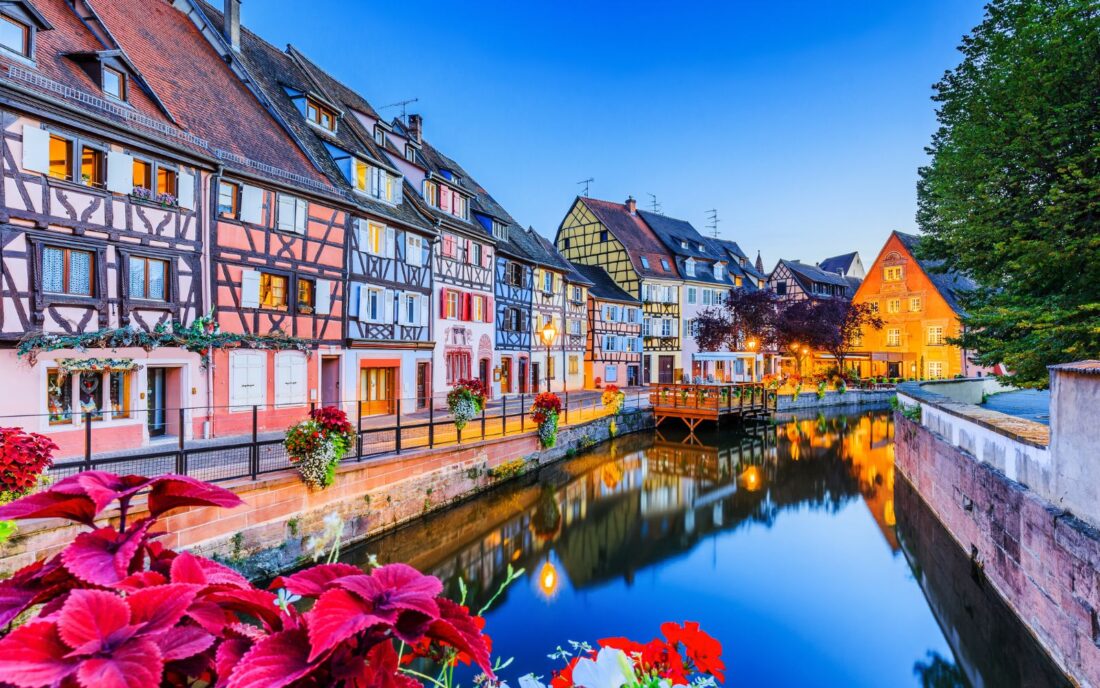 At Colmar in Alsace, France, you see a traditional half-timbered homes and a water canal.