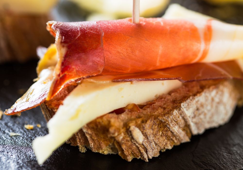 Spanish tapas with a slice of bread, cheese, and Spanish ham