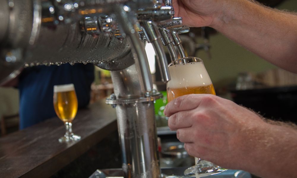 Bartender pouring beer from tap on a bozeman brewery tour