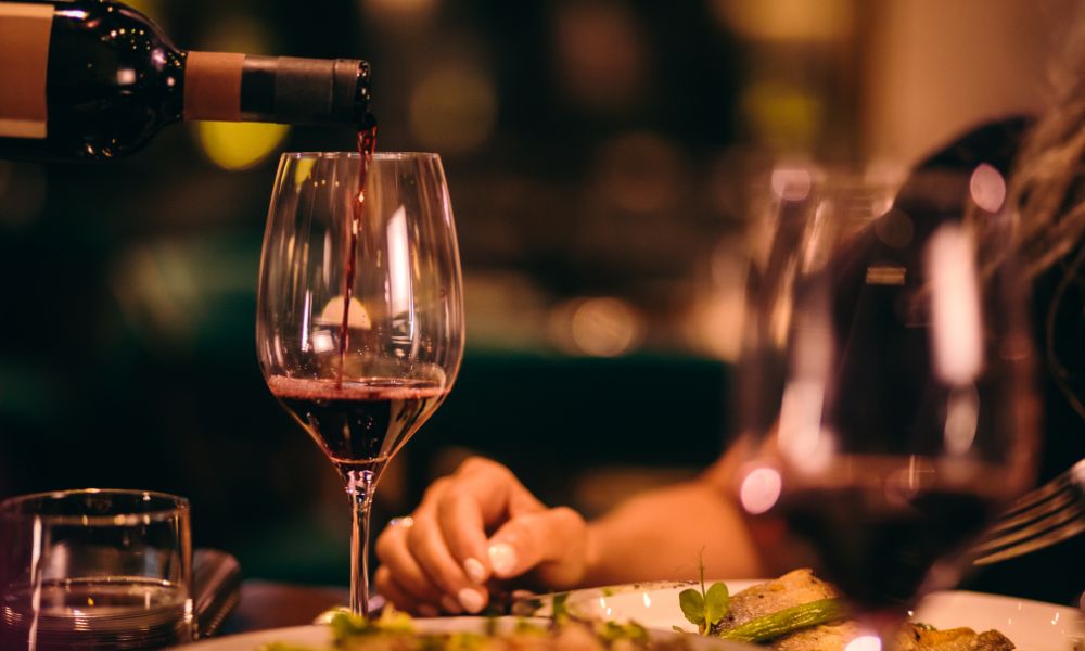 wine being poured into a glass at a restaurant fine dining in paros