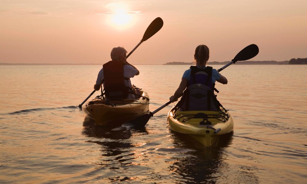 two people kayaking at sunset in mykonos