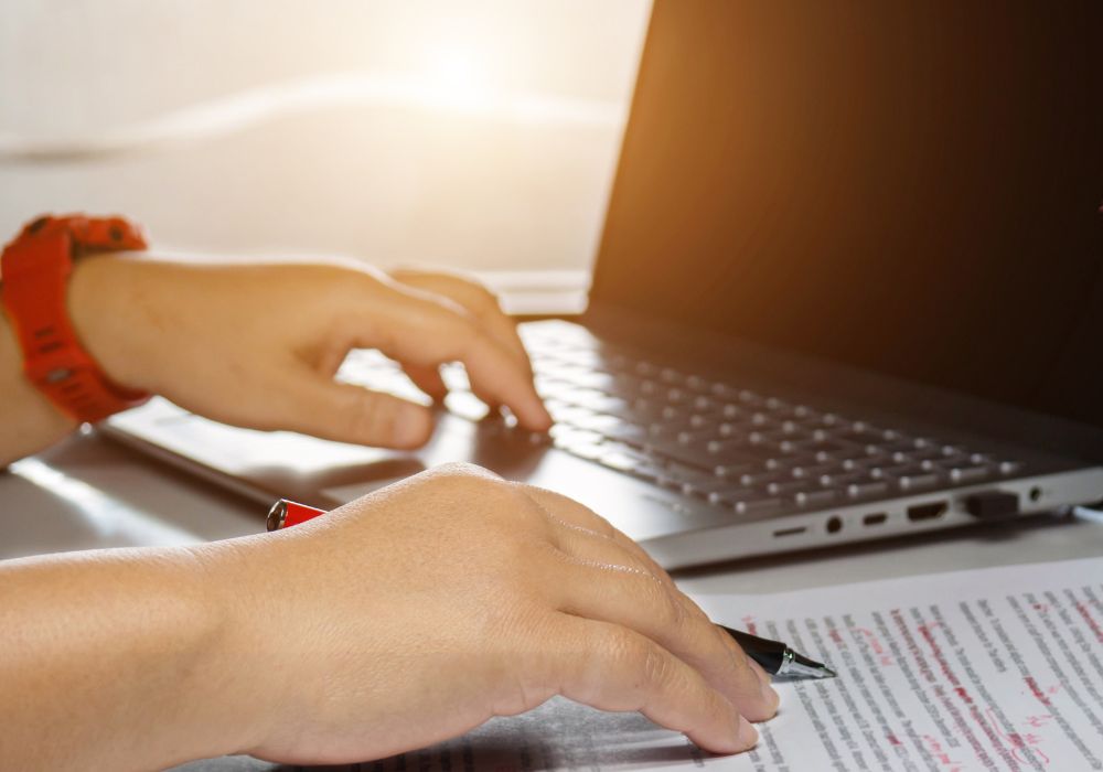 A young man is proofreading and editing on an office table.