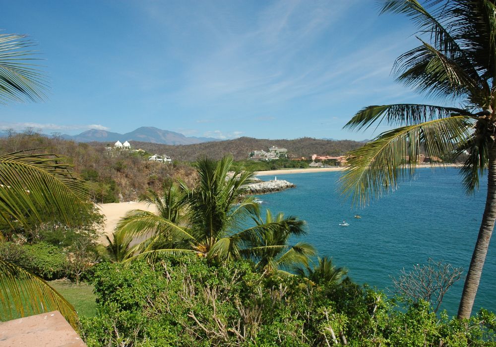 huatulco beach is one of the top places to visit in mexico. with palm trees and mountains