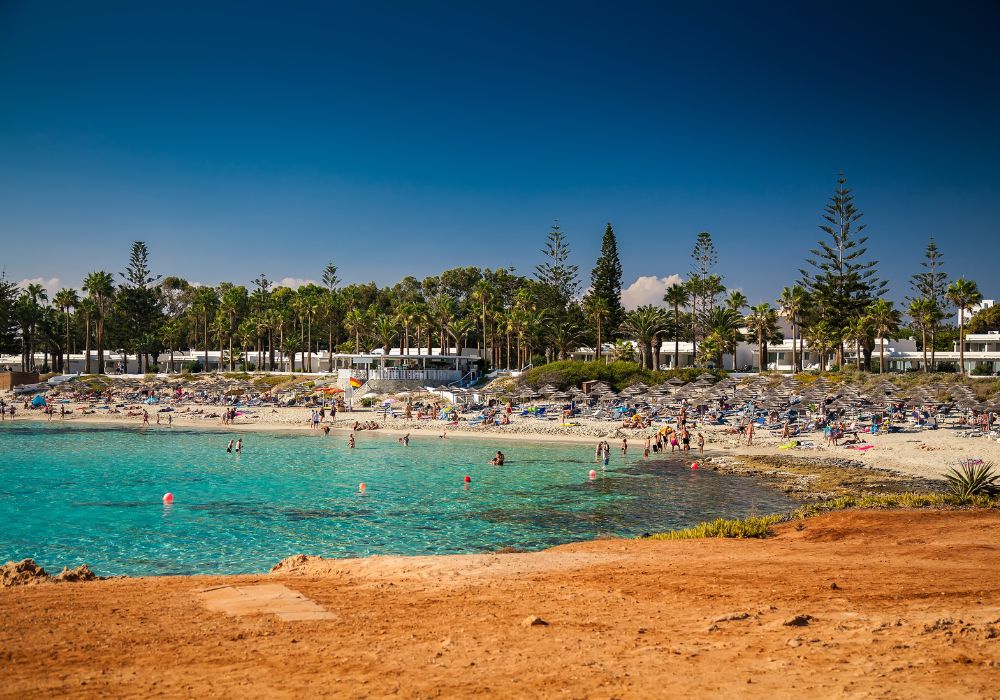 shallow water at nissi beach in cyprus with peopel on the sand