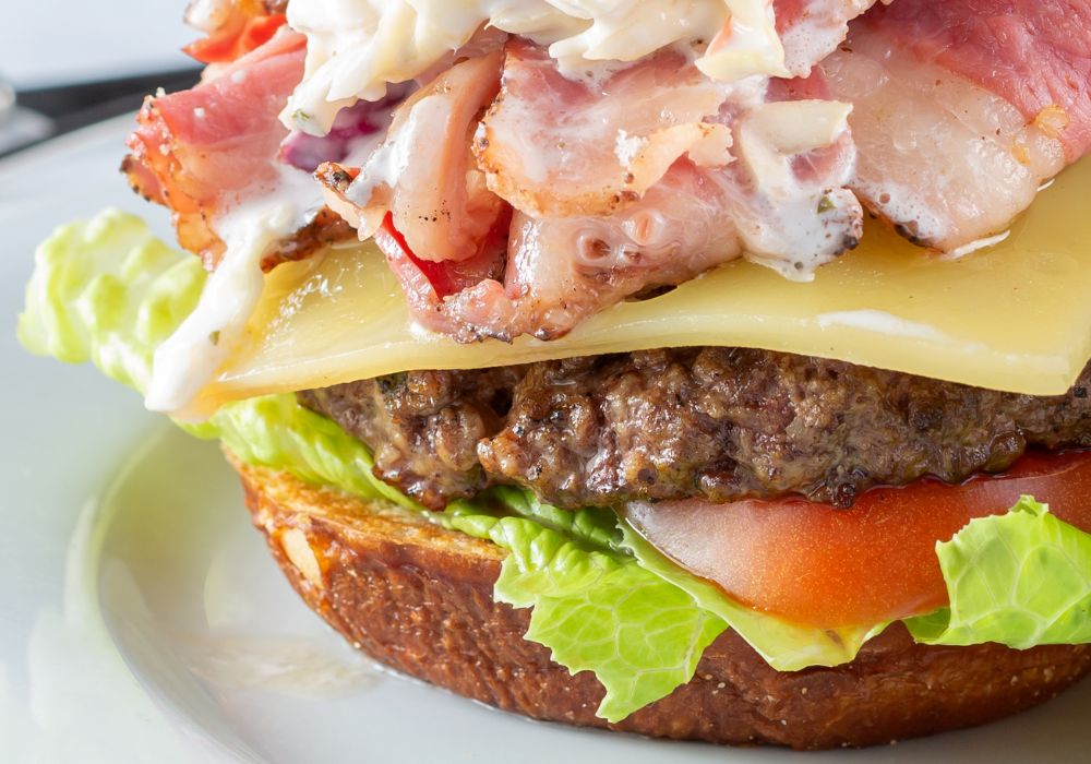 A closeup view of an open pastrami burger in a restaurant.