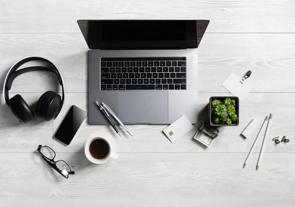 Nomadic workspace with supplies and gadgets on wooden background