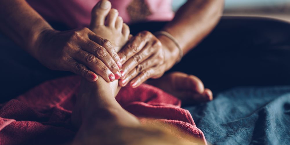 Thai masseuse from a woman's prison working a customer's feet