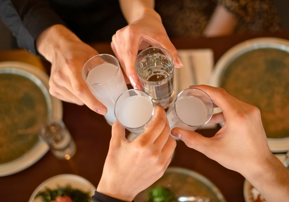 Close up of friends having fun and toasting with raki