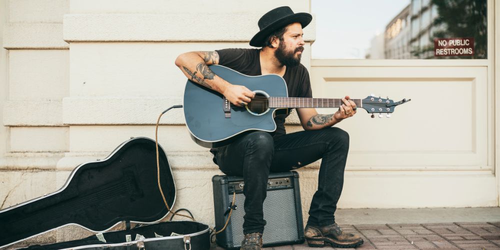 A busker playing guitar on the street