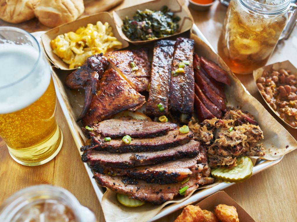 bbq plate with brisket and chicken adn macaroni and cheese and collard greens