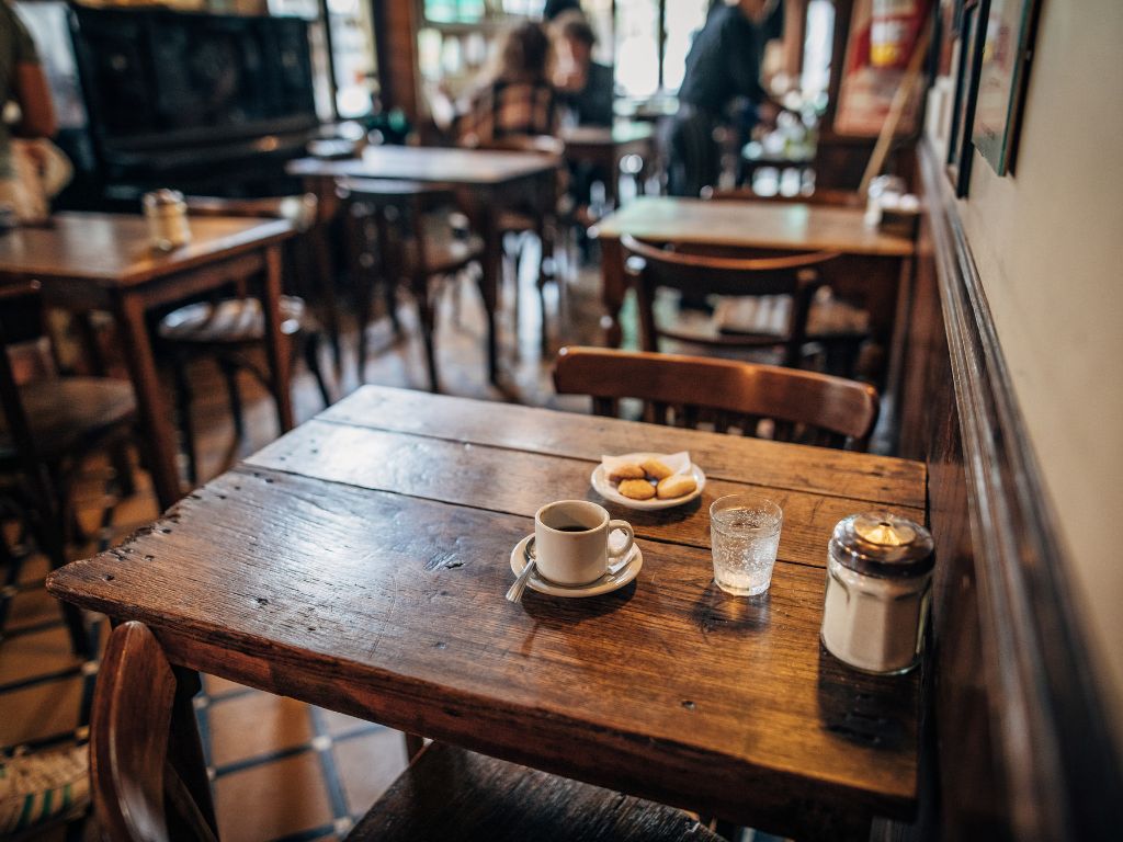 a cafe with wooden tables and some cookies and coffee on the talbe