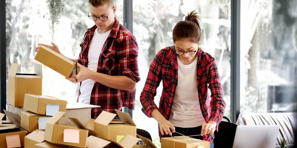 Man and woman packing boxes to be shipped